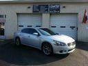 Silver sedan parked in front of a building with garage doors