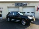 Black SUV parked in front of a garage with closed white doors