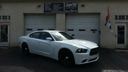 White sports coupe parked in front of a garage with closed doors