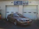 Gray car parked in front of two white garage doors