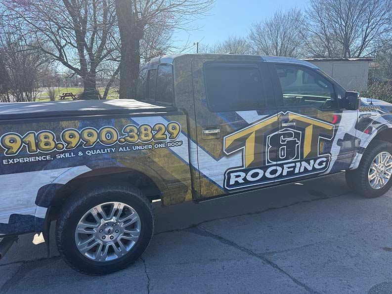 A truck wrapped in a T&T Roofing graphic with a gold, 
