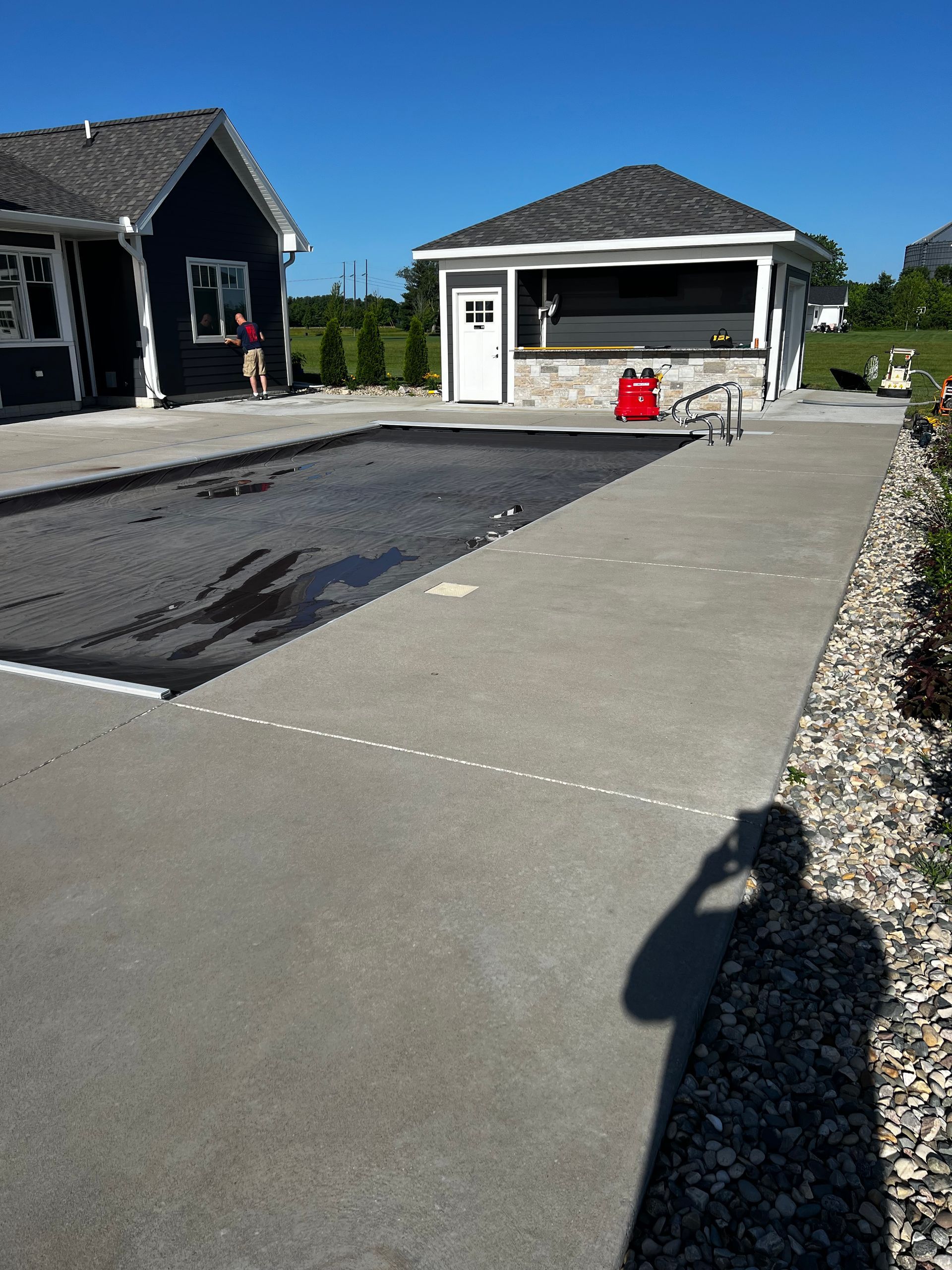 A shadow of a person taking a picture of a swimming pool