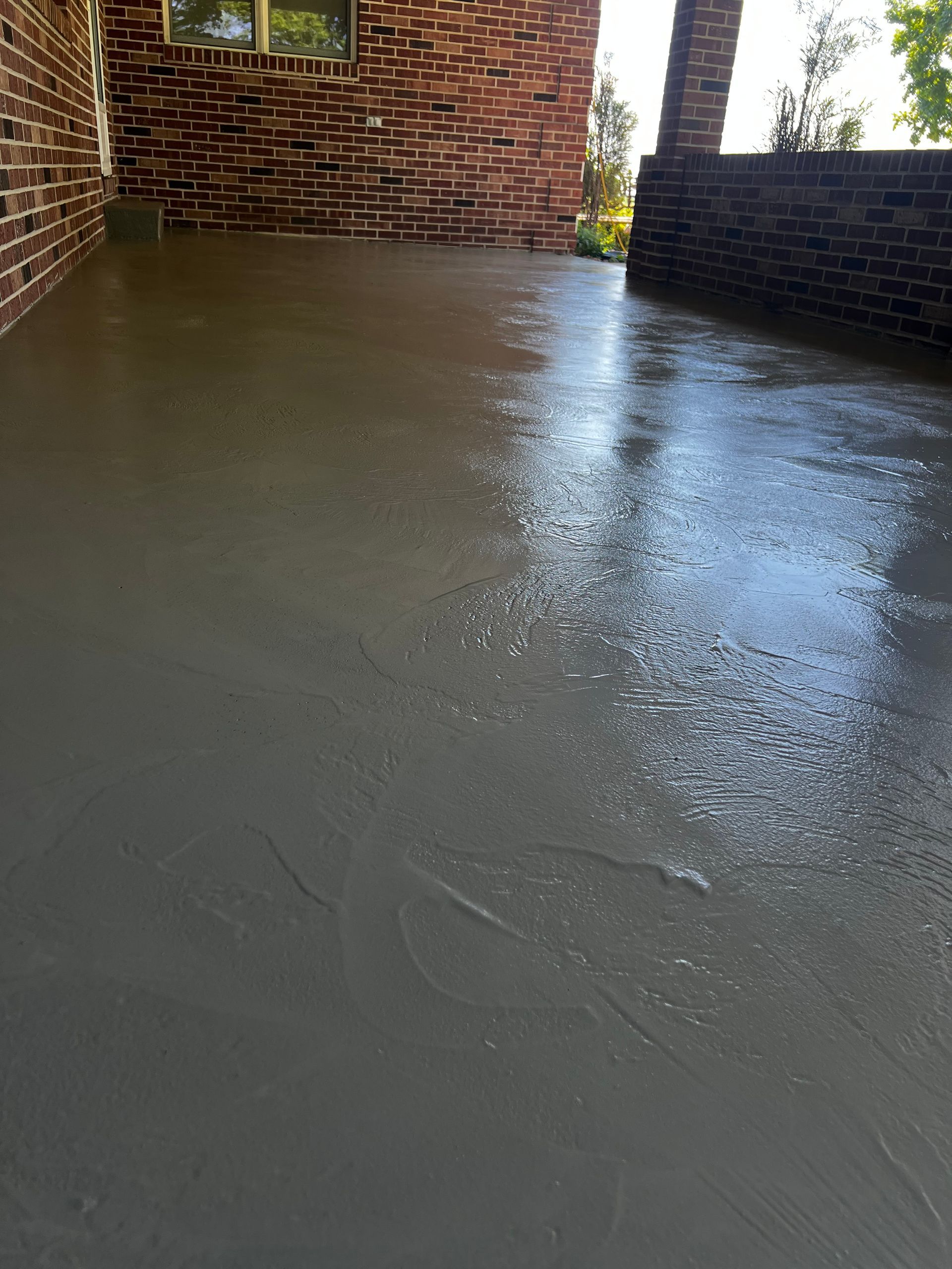A brick building with a concrete floor in front of it.
