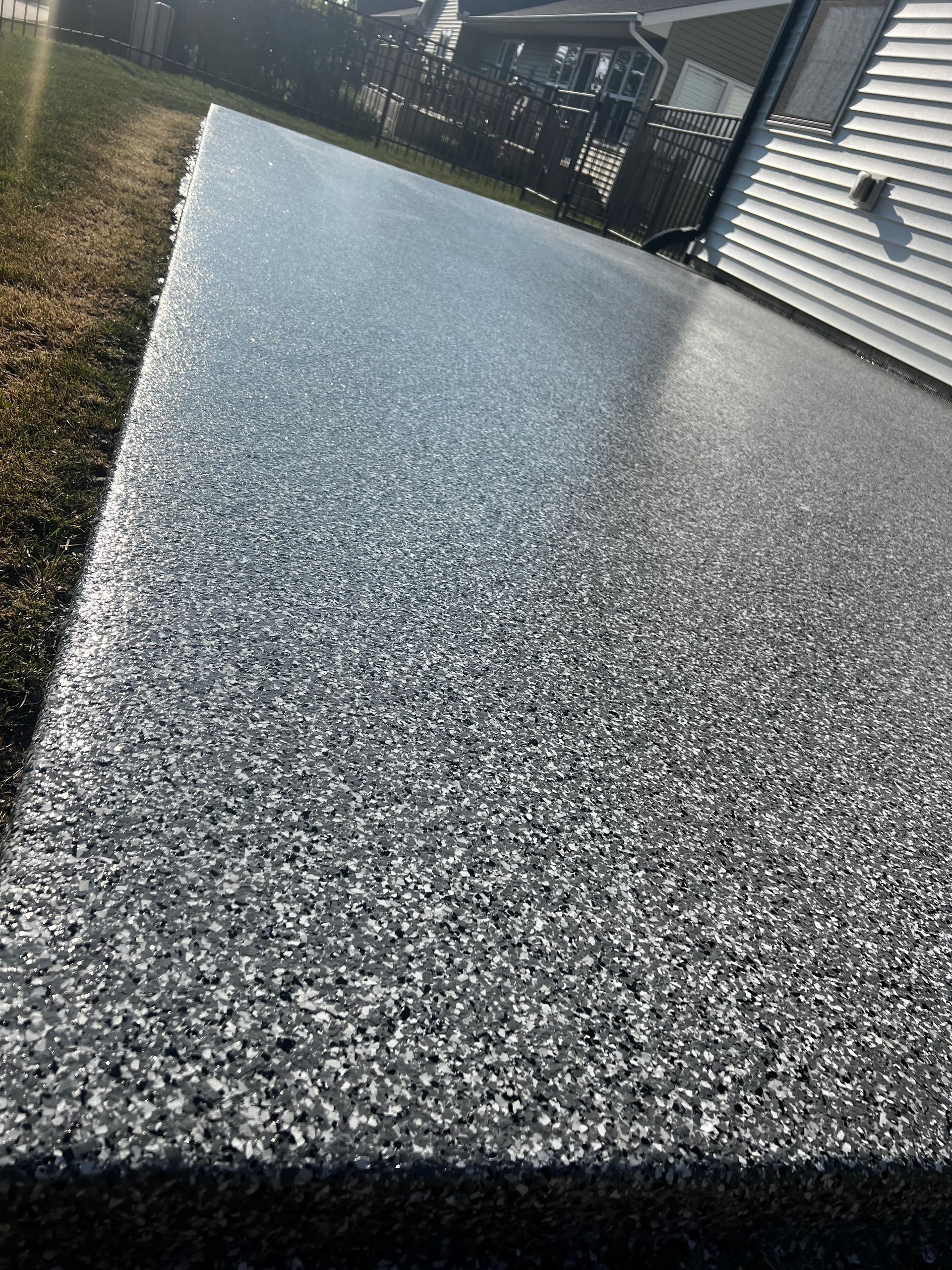 A close up of a concrete deck with a house in the background.