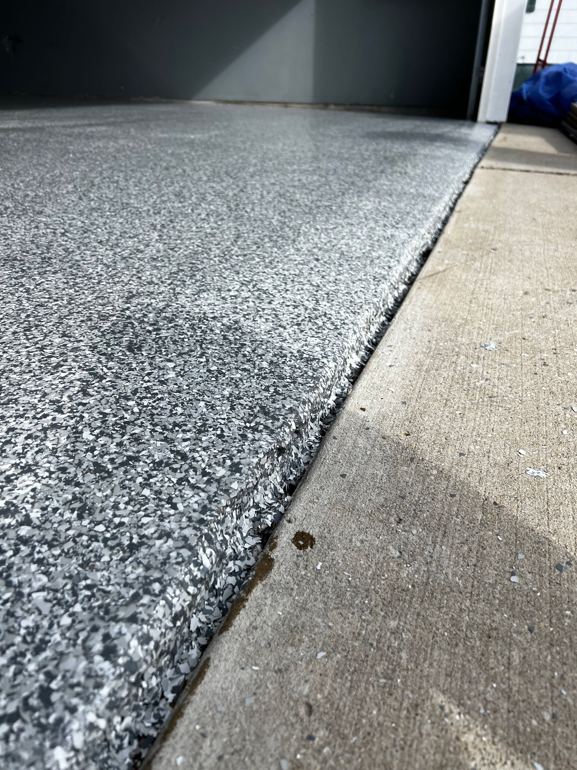 A close up of a gray carpet on a concrete floor.