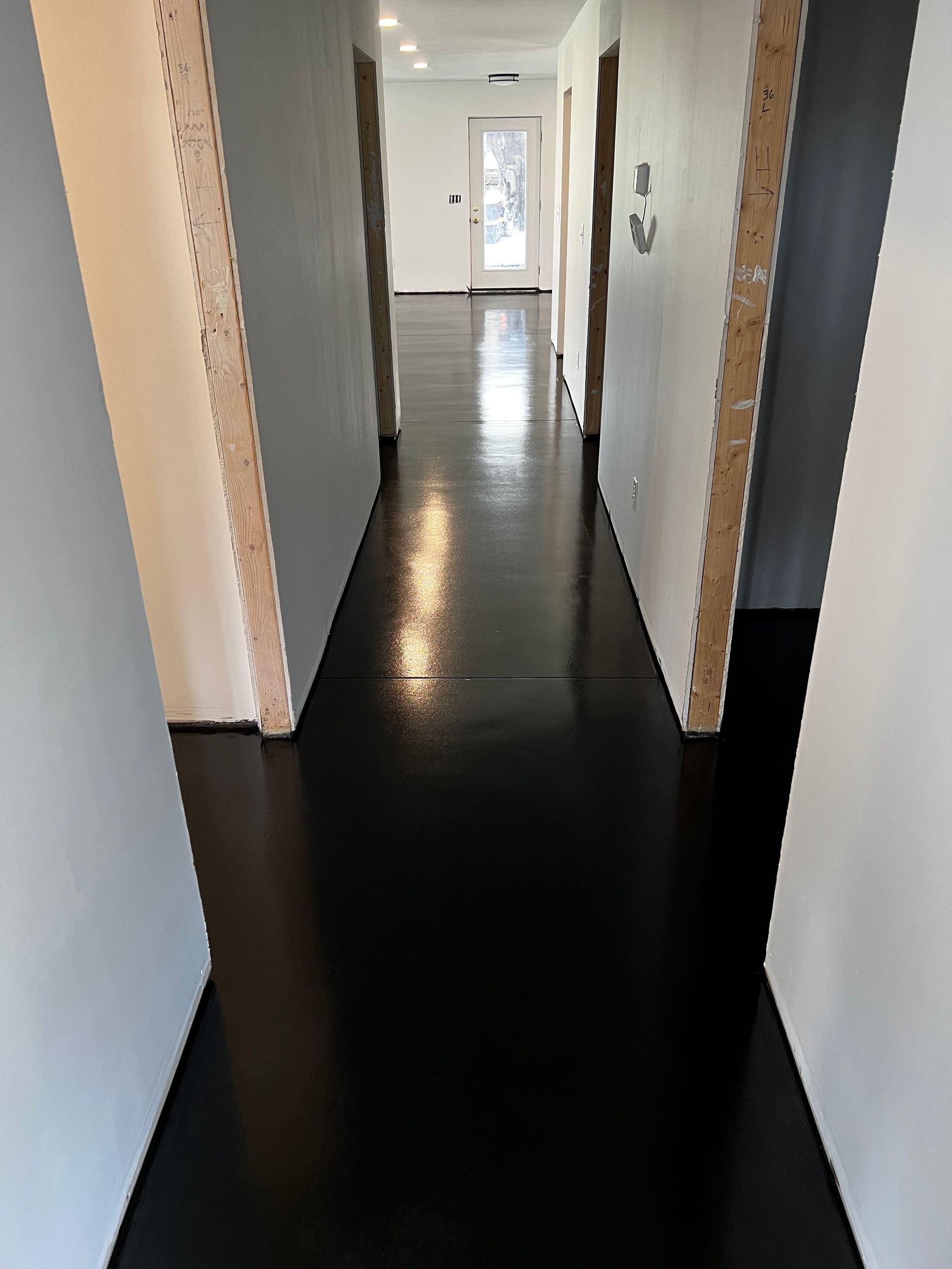 A hallway with a black floor and white walls