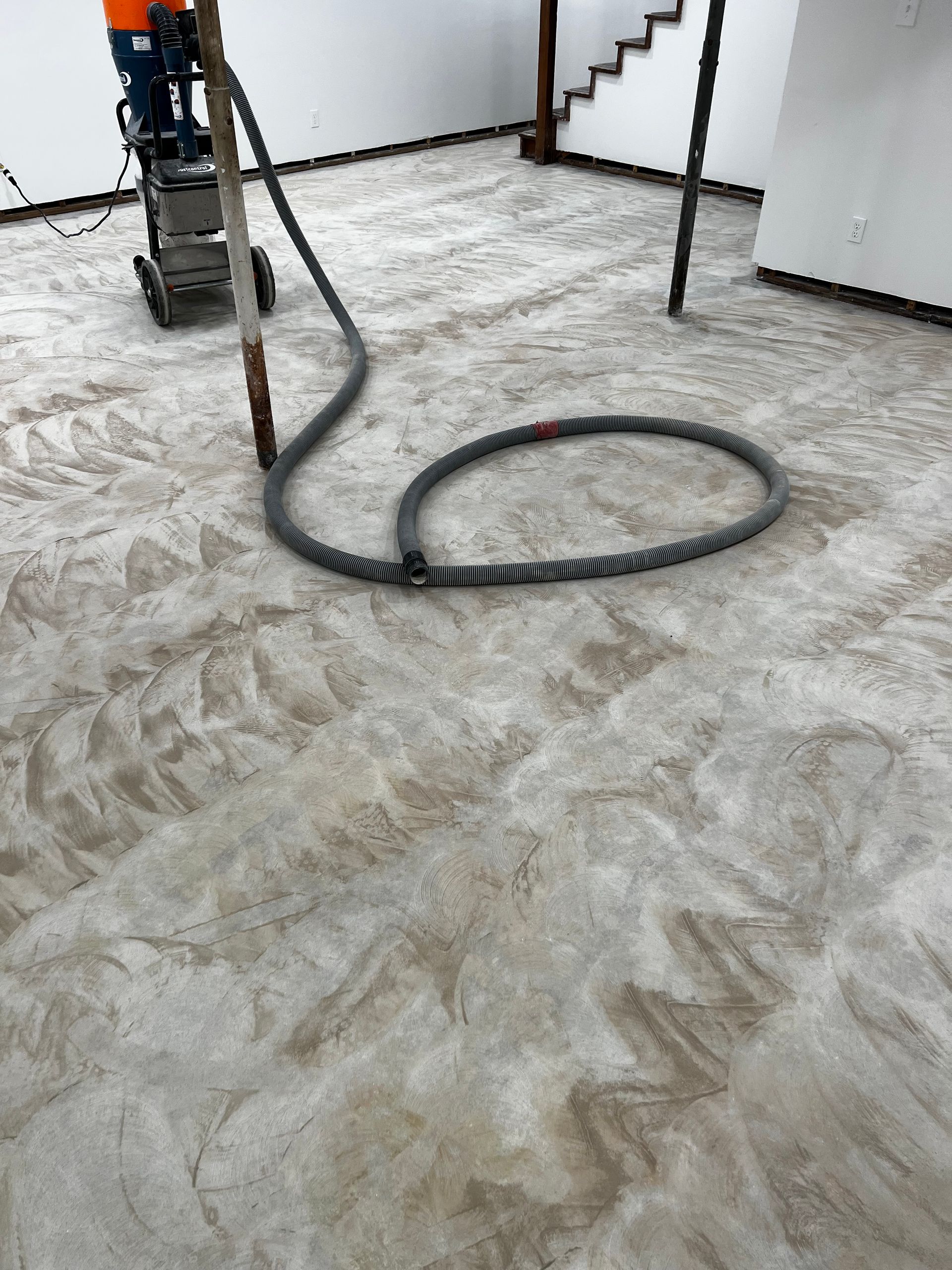 A vacuum cleaner is being used to clean a concrete floor