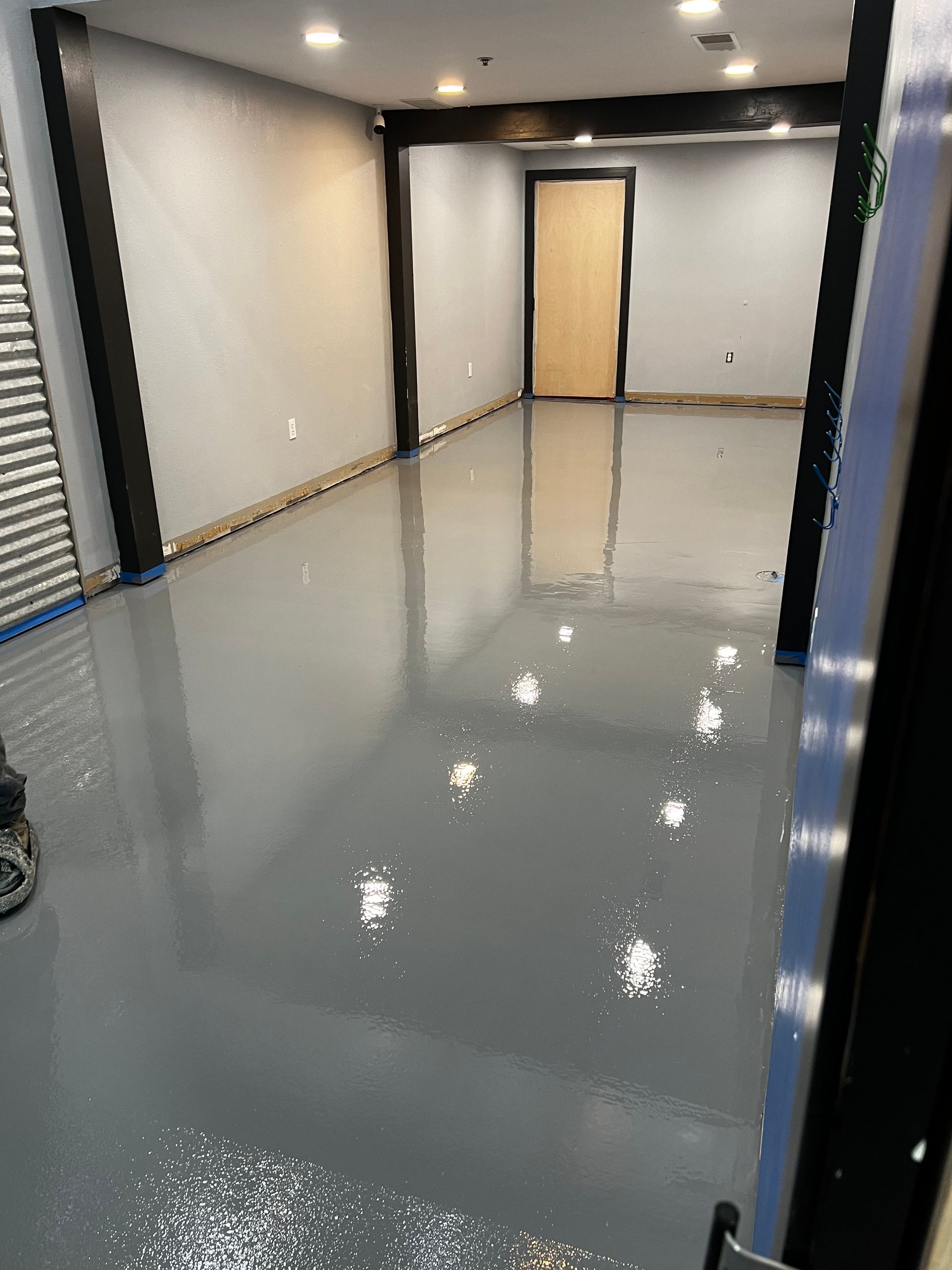 A large room with a concrete floor and a door.