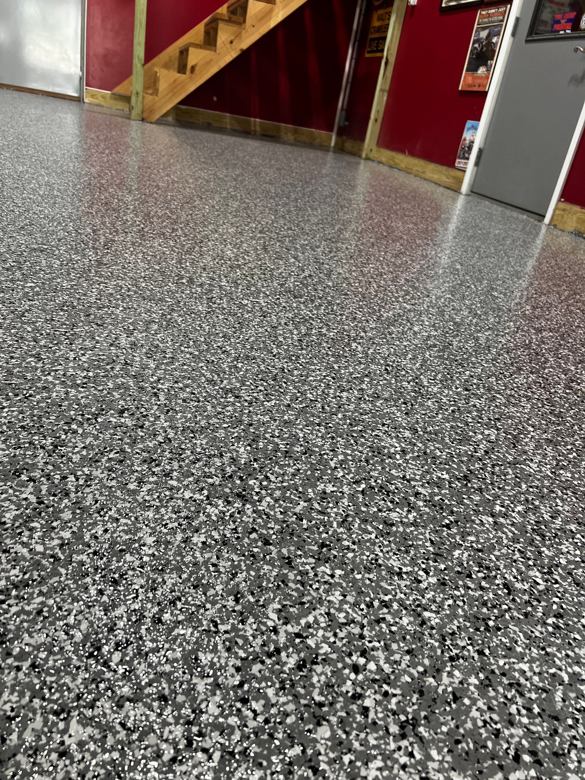 A close up of a garage floor with a staircase in the background.