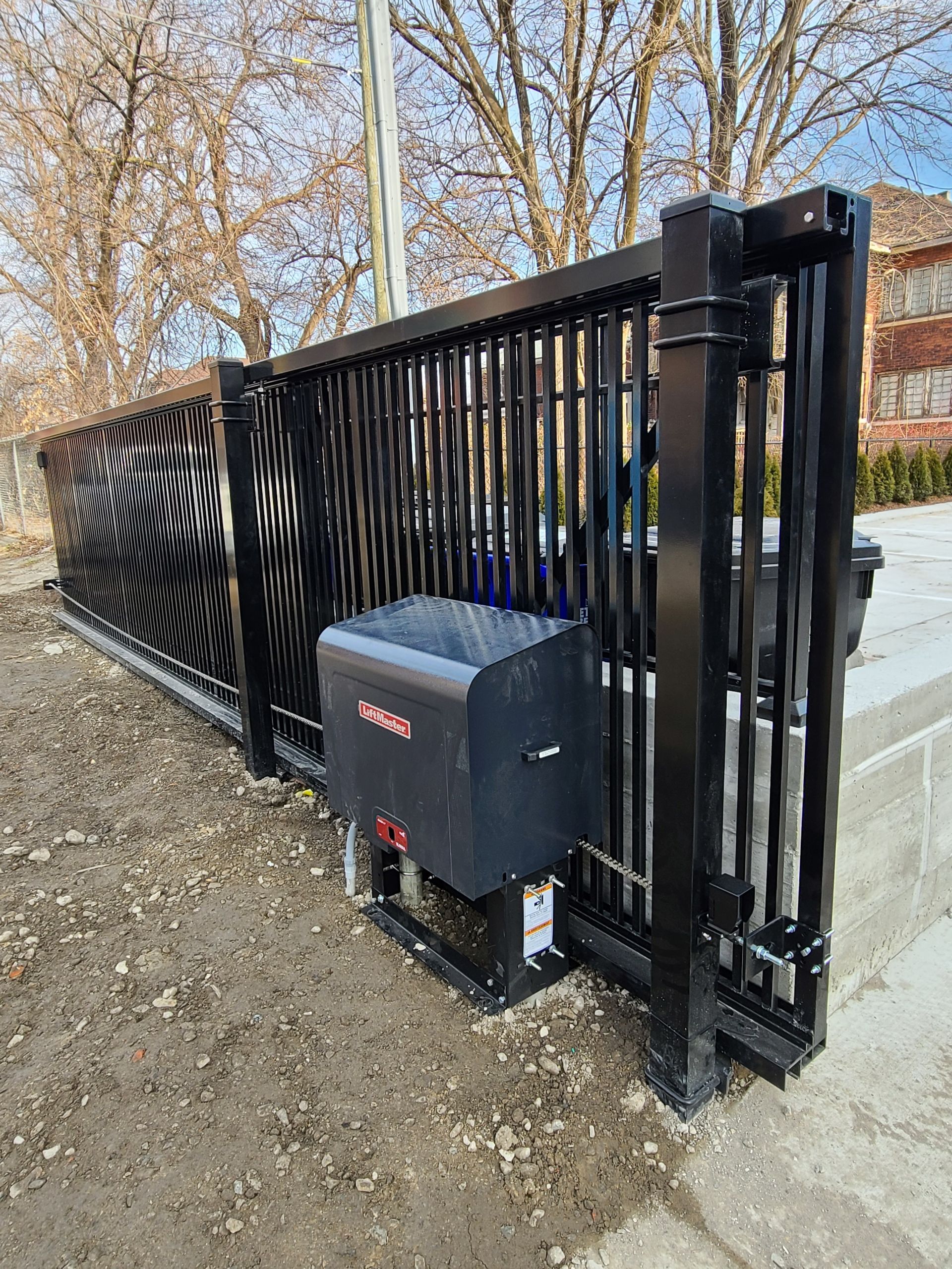 Black commercial sliding gate with gate operator installation in Metro Detroit by Eastside Fence