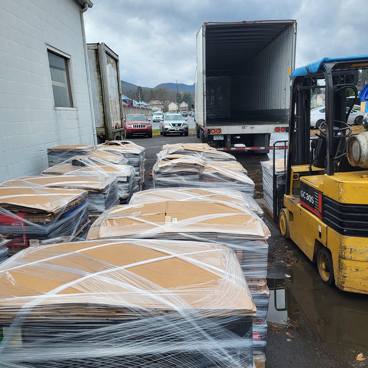 A forklift is loading cardboard boxes into a truck.