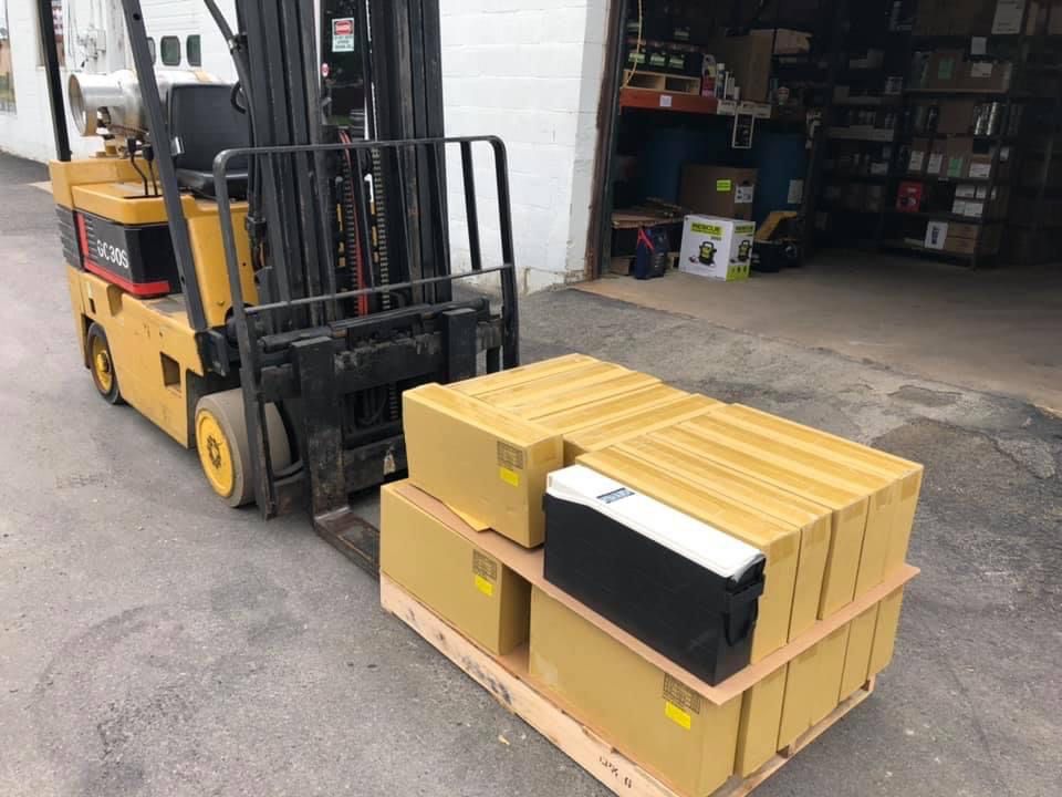 A forklift is carrying a pallet of boxes in a warehouse.