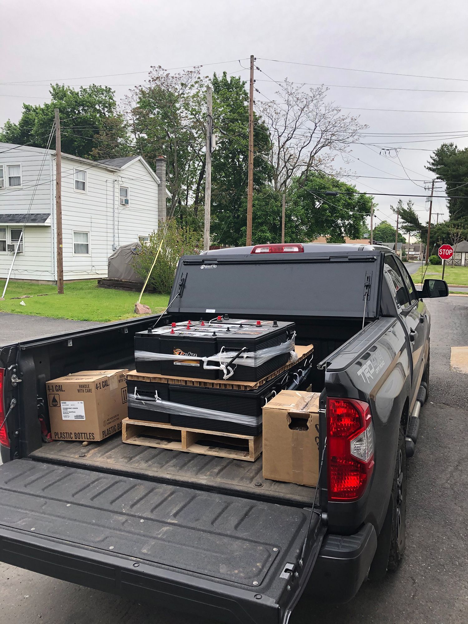 A truck is loaded with batteries and boxes in the back.