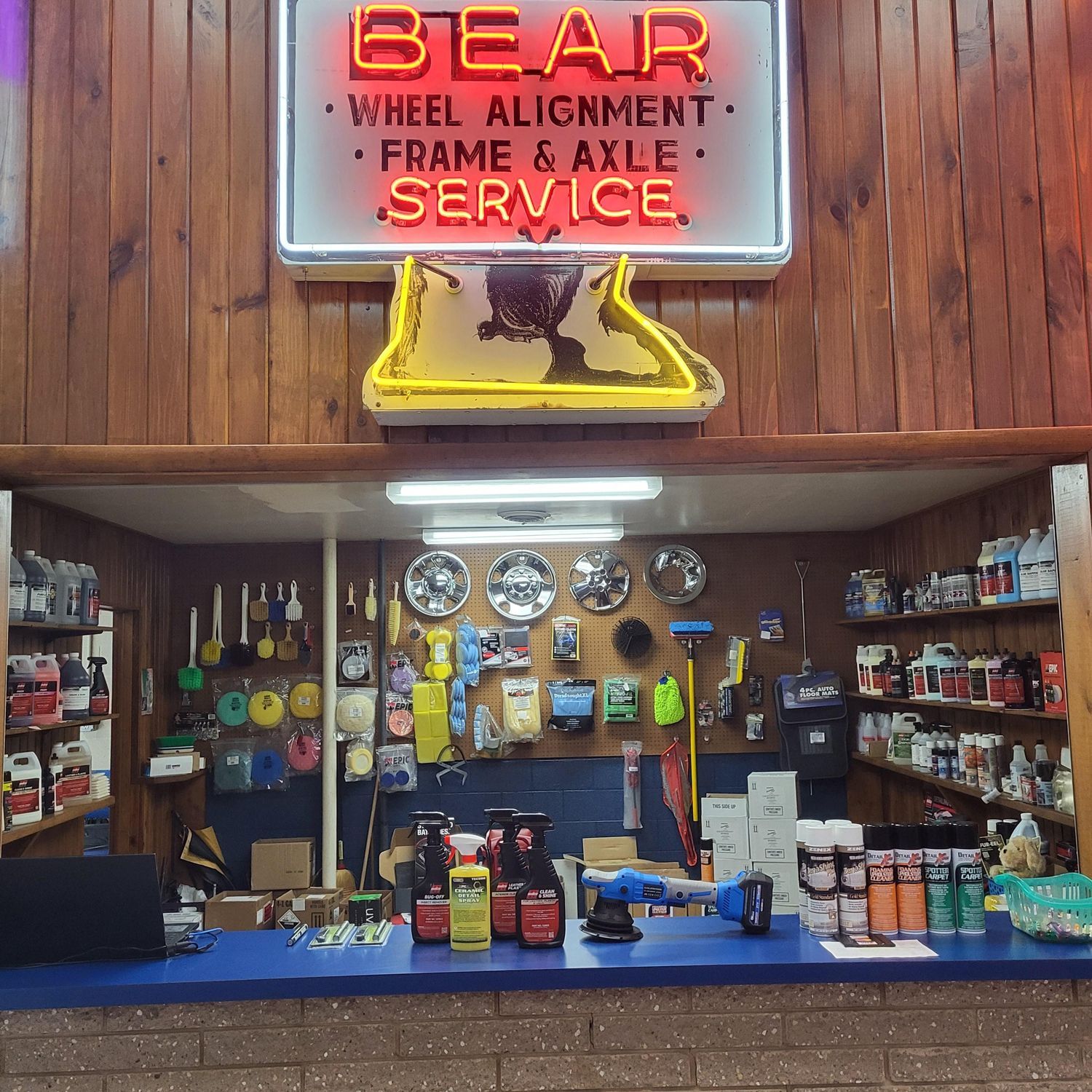 A neon sign for bear wheel alignment frame and axle service