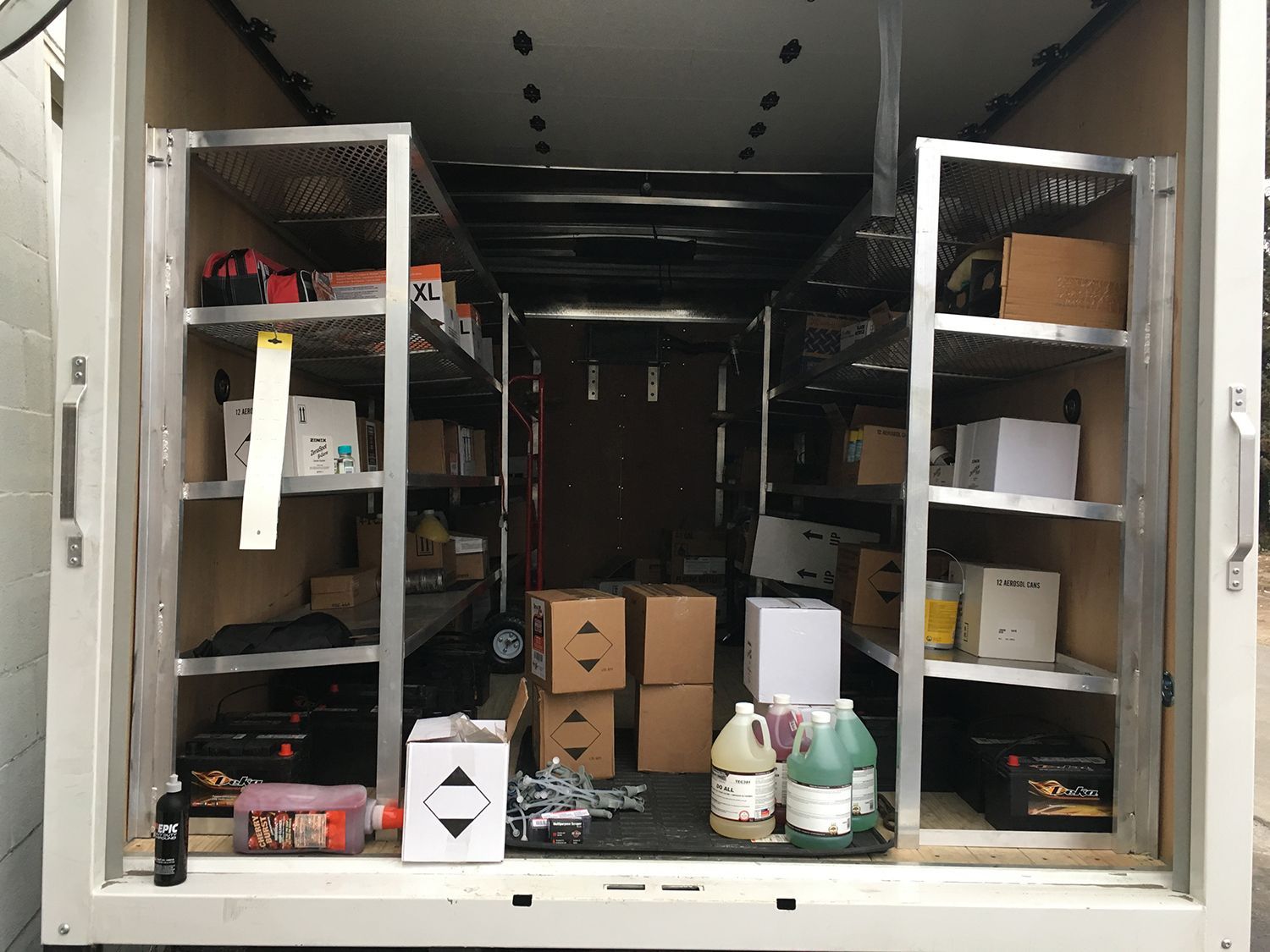 The inside of a trailer filled with boxes and shelves.
