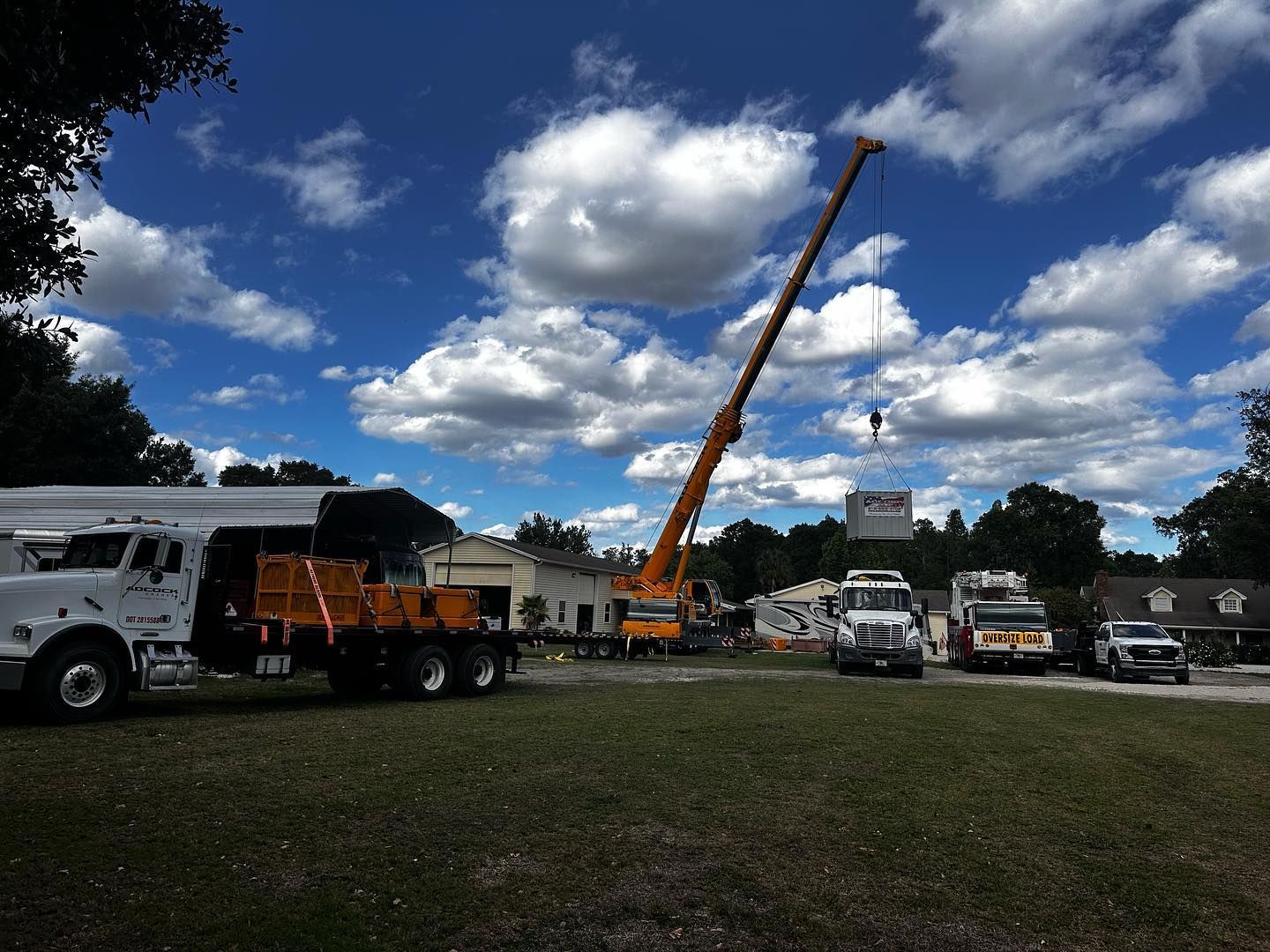 A truck with a crane on top of it is parked in a grassy field.