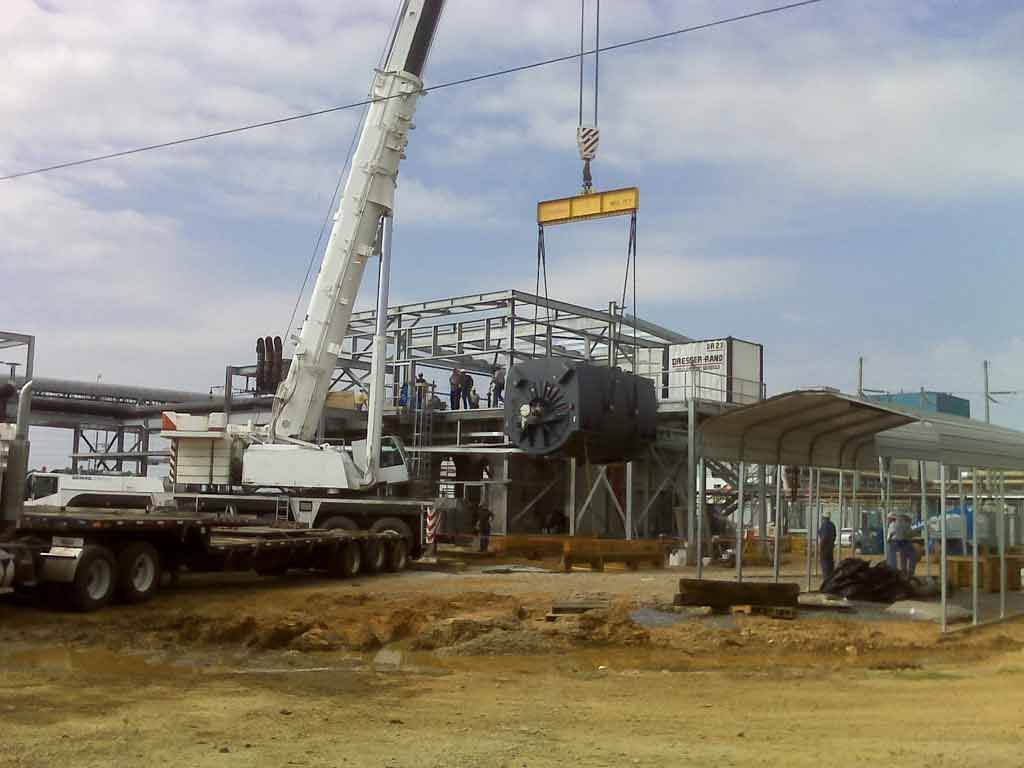 A large crane is lifting a large metal structure in a construction site