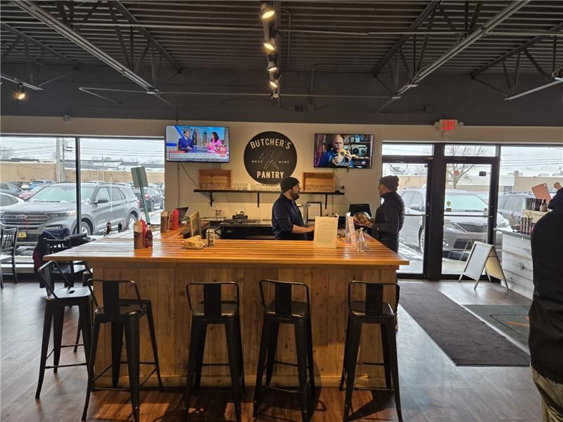 A man is standing at a counter in a restaurant.