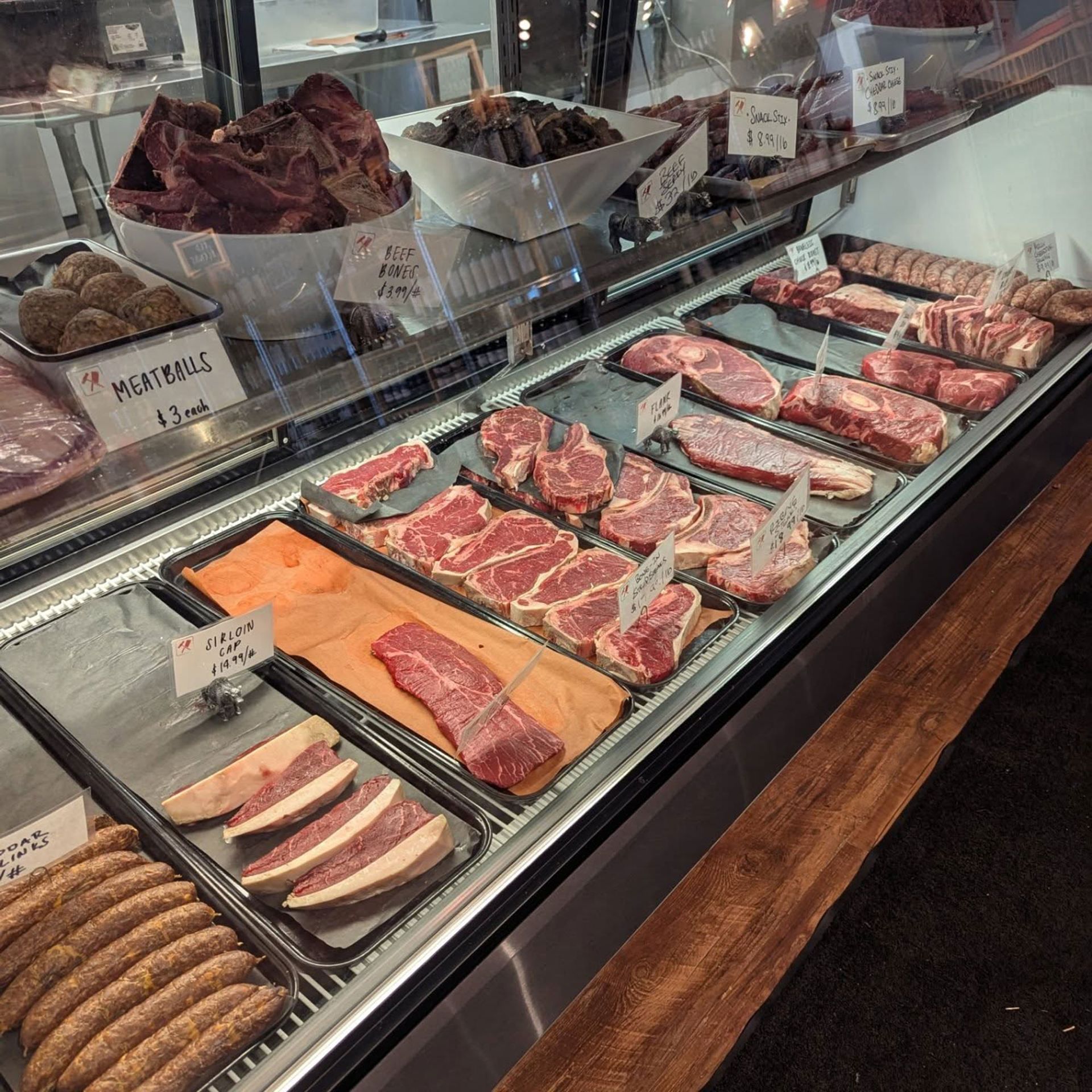 A butcher 's display case filled with meats and sausages