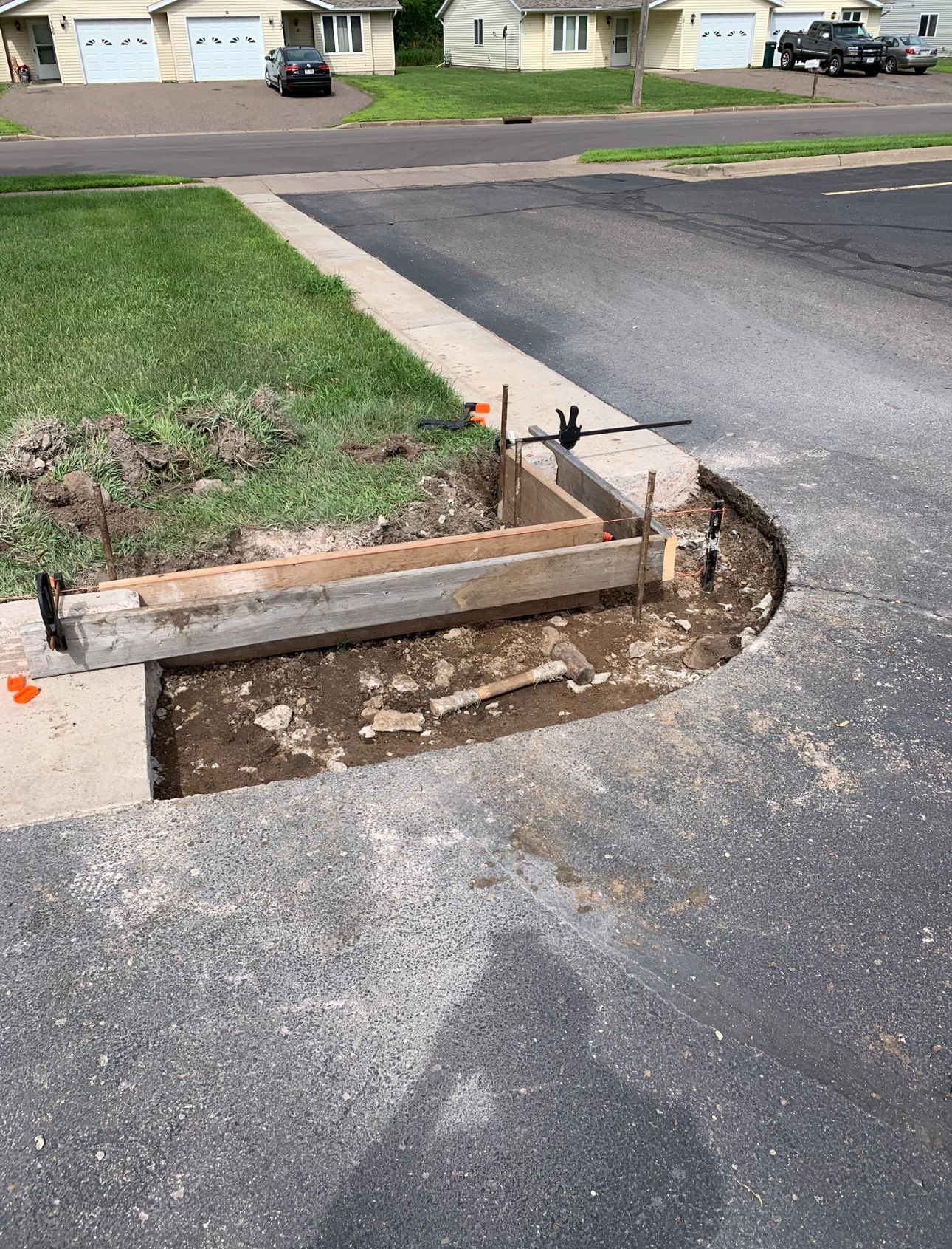 A concrete curb is being built in the middle of a driveway.