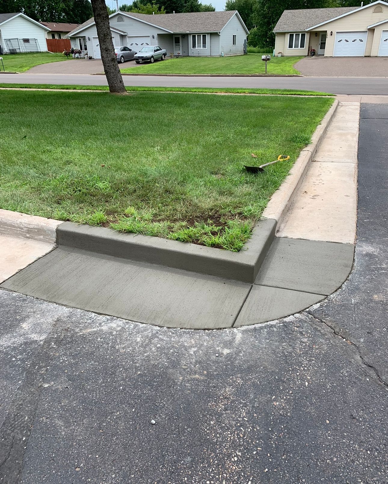 A concrete curb is being installed in front of a house.