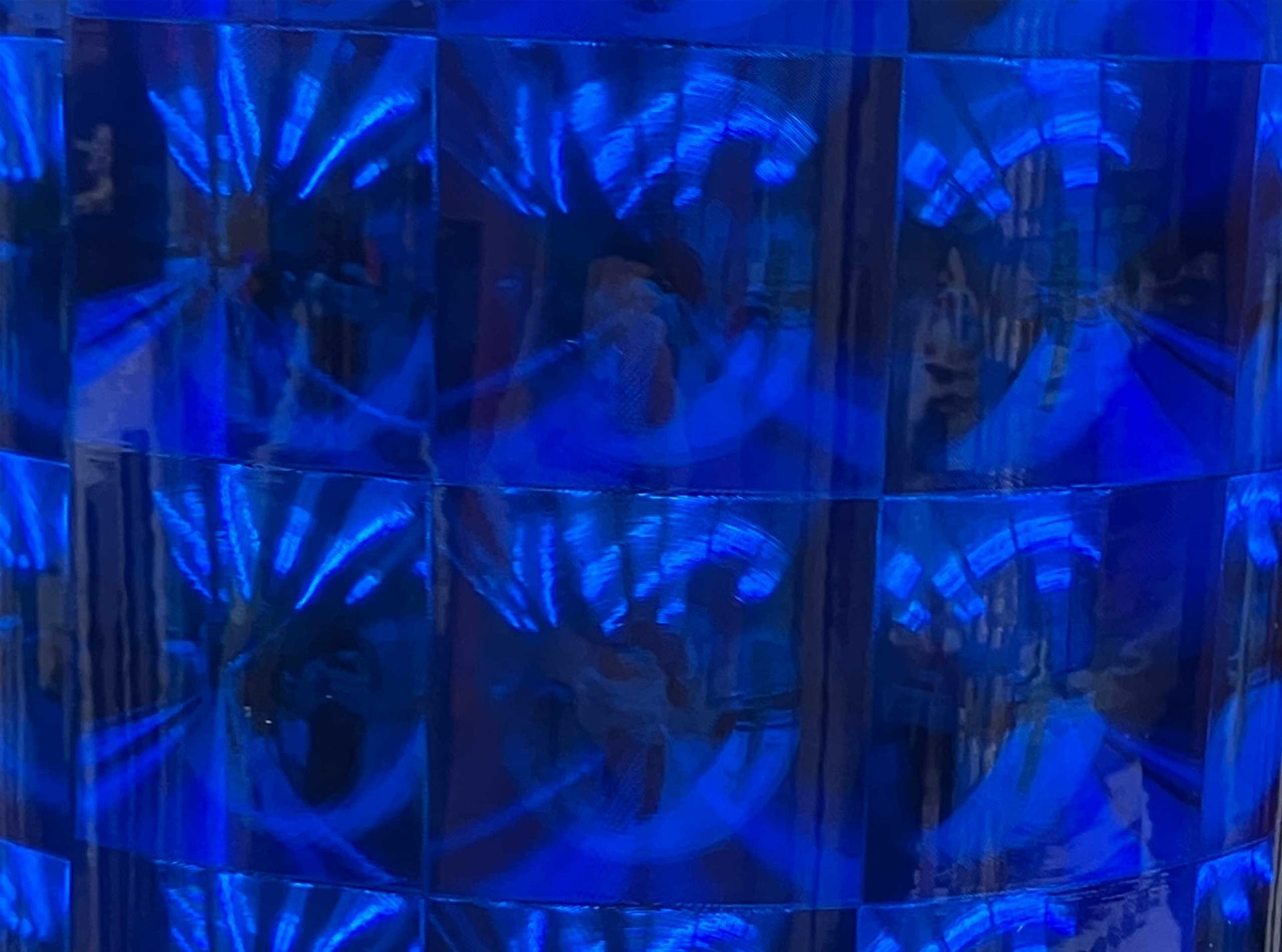 Blue abstract pattern of reflective geometric tiles with bright highlights