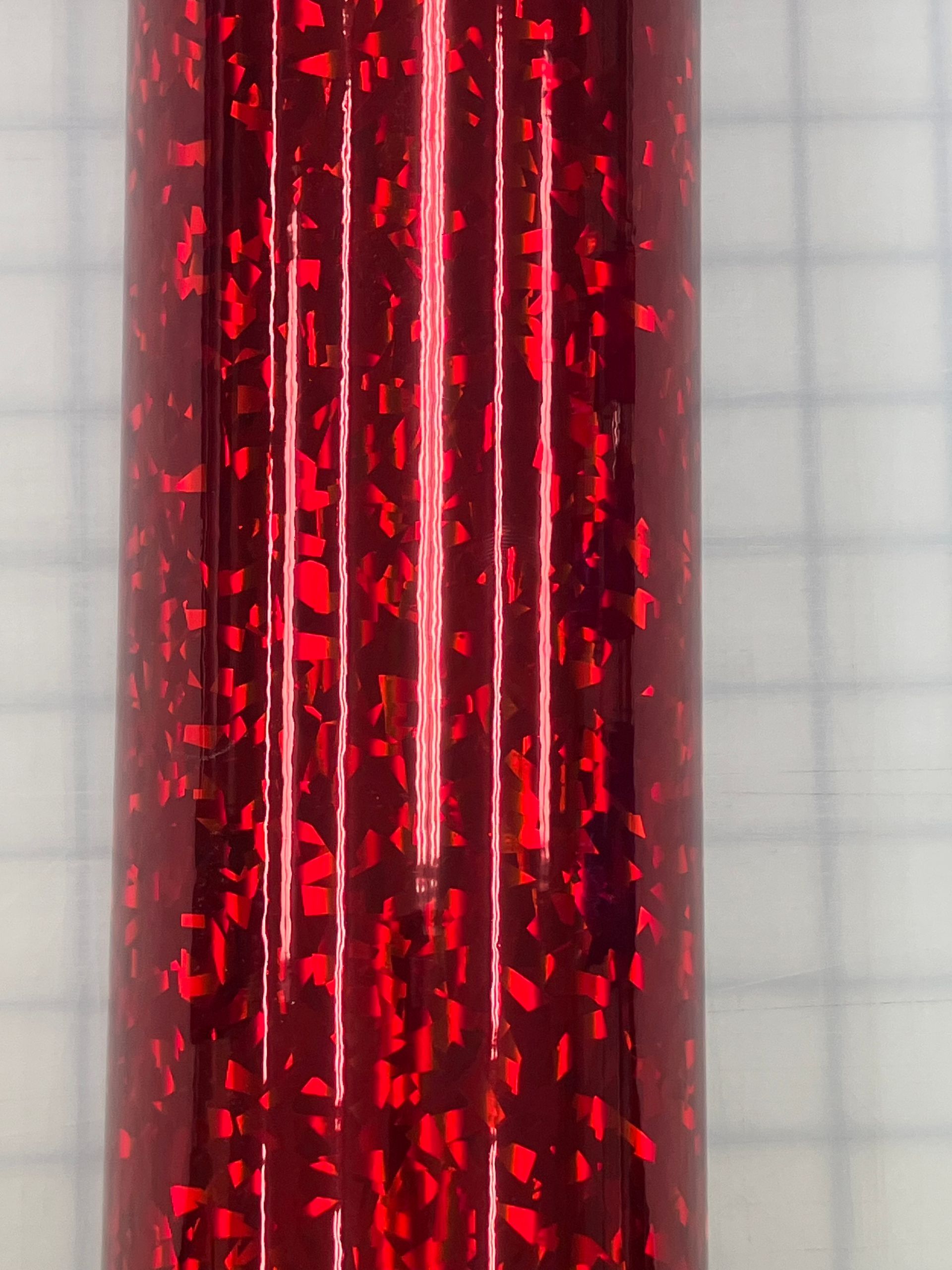 Close-up of red glittery vertical ribbons with a glossy metallic sheen.