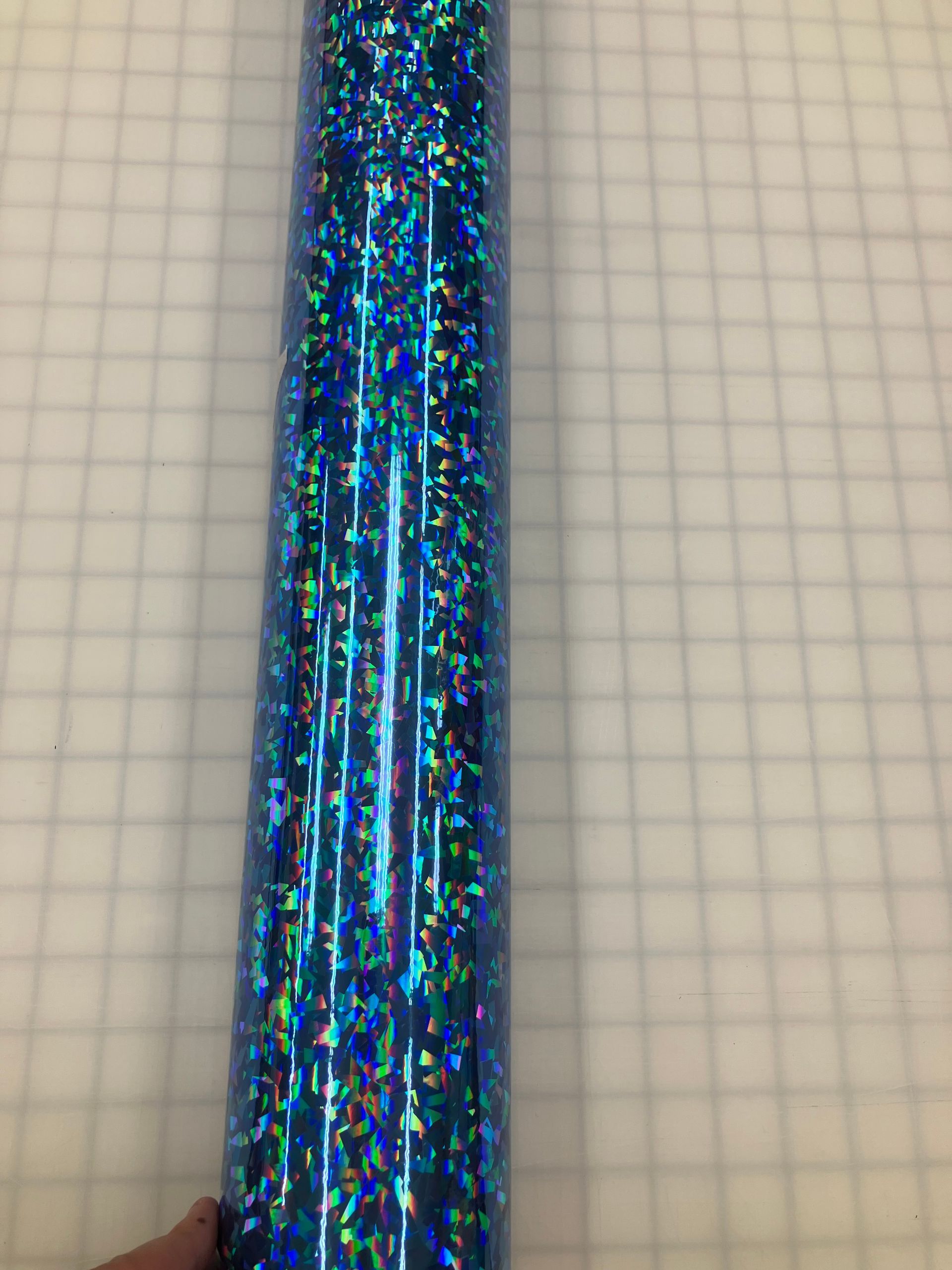 Blue glittery metallic fabric or ribbon on graph paper background