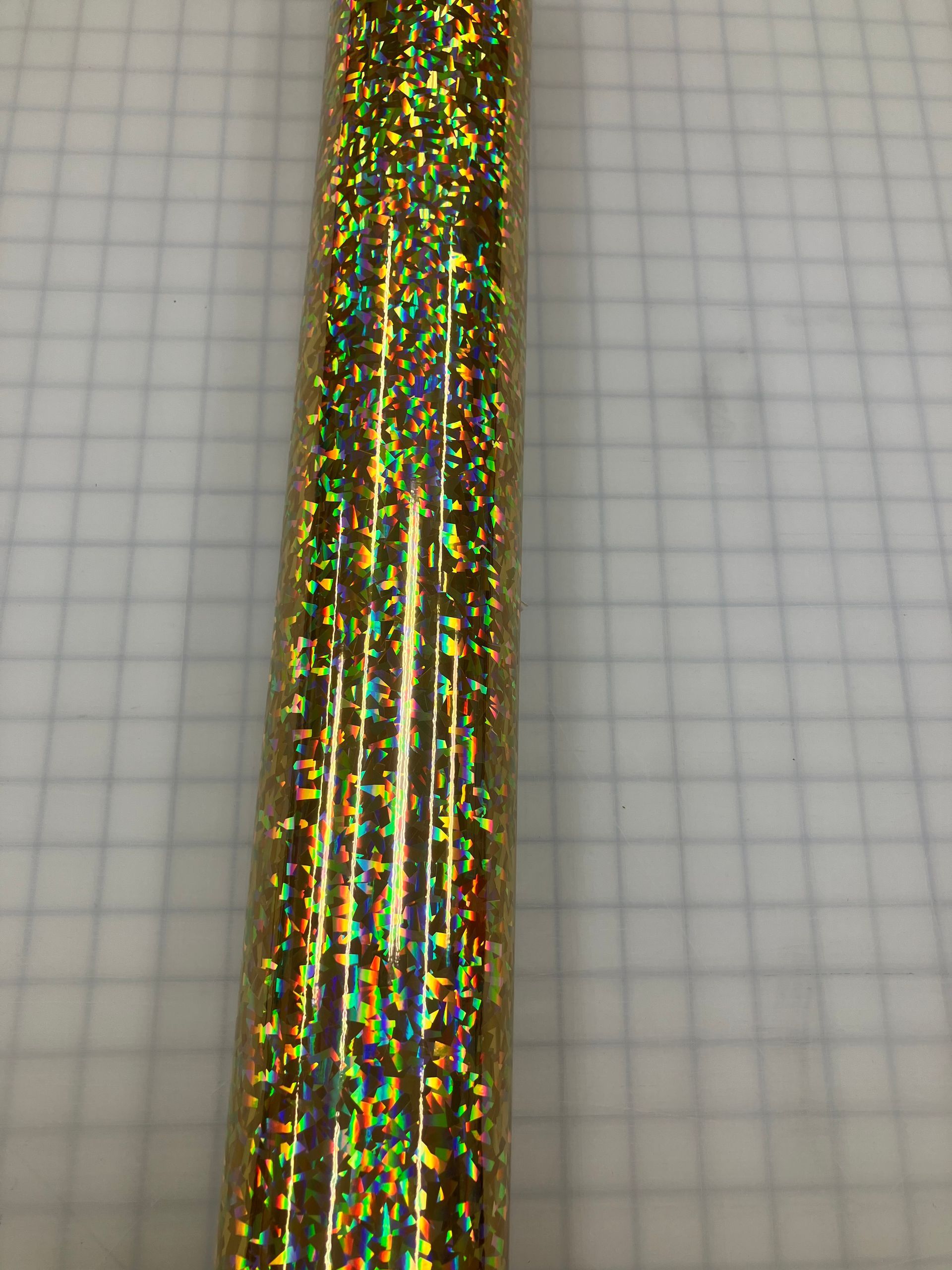Gold glittery tinsel or ribbon against a gray grid background