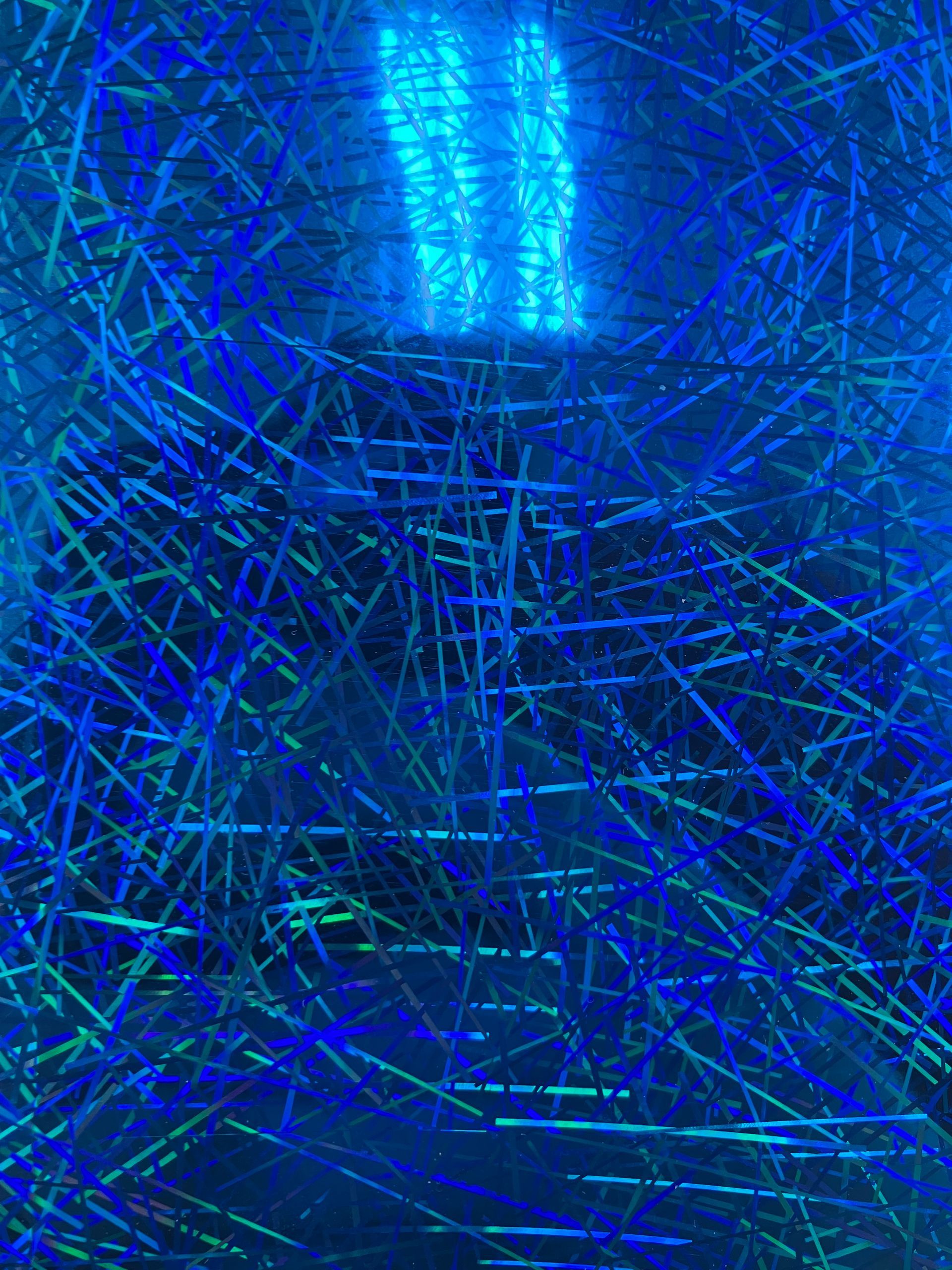 Abstract blue and green neon-like lines crisscross a dark background with a glowing center