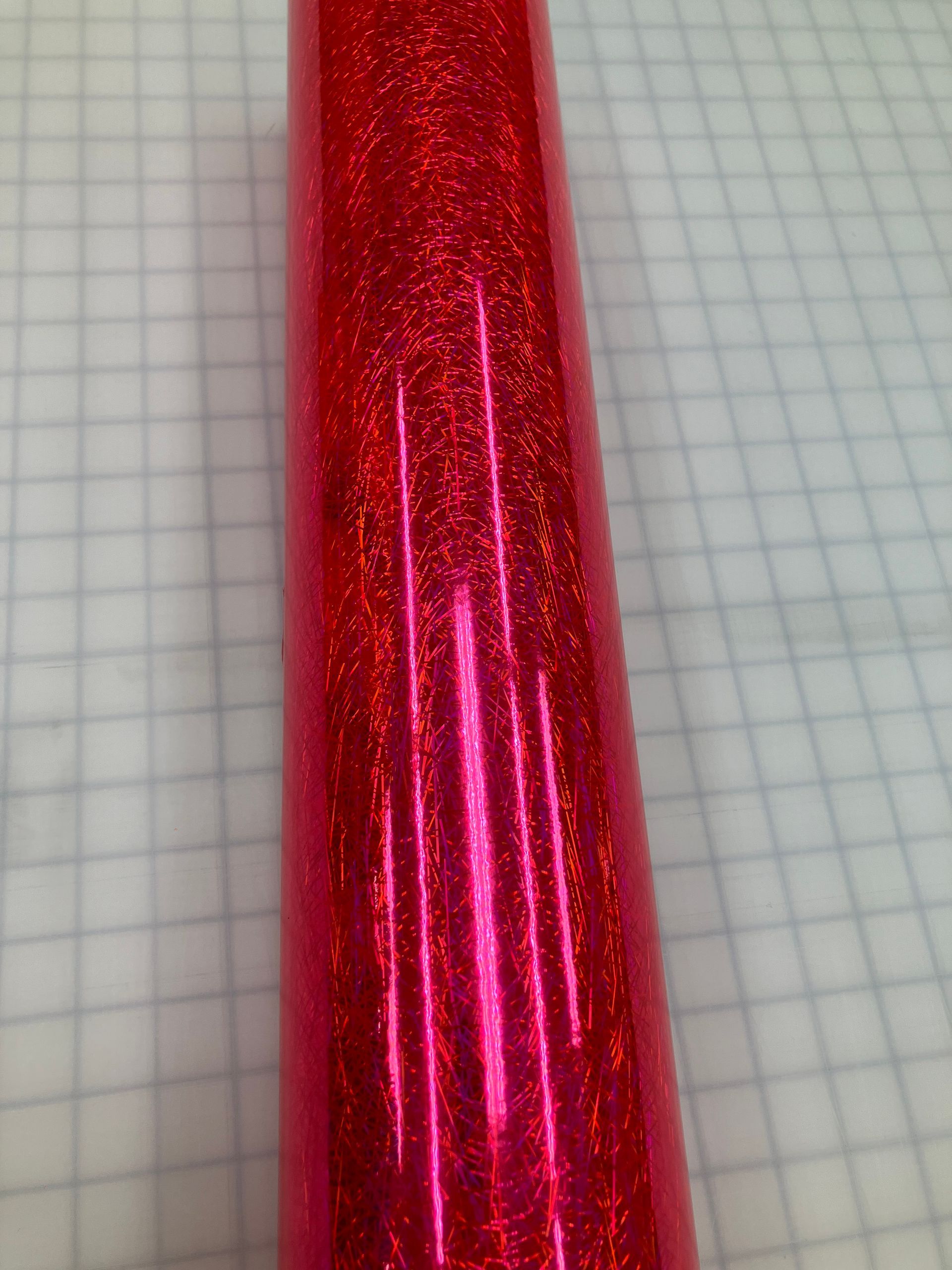 Red metallic glitter cone-shaped object on graph paper background