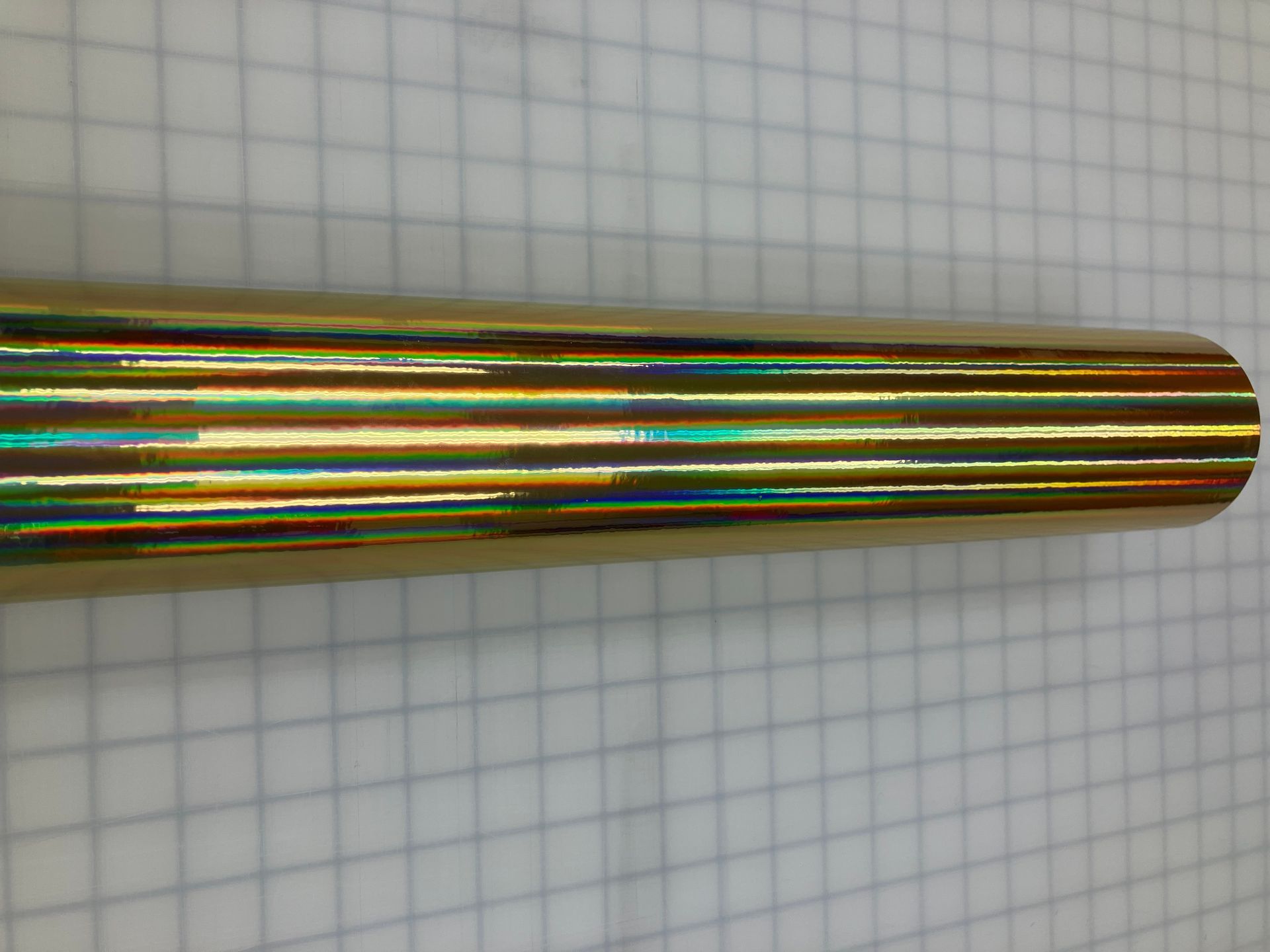 Multicolored metallic cylindrical rod on graph paper background