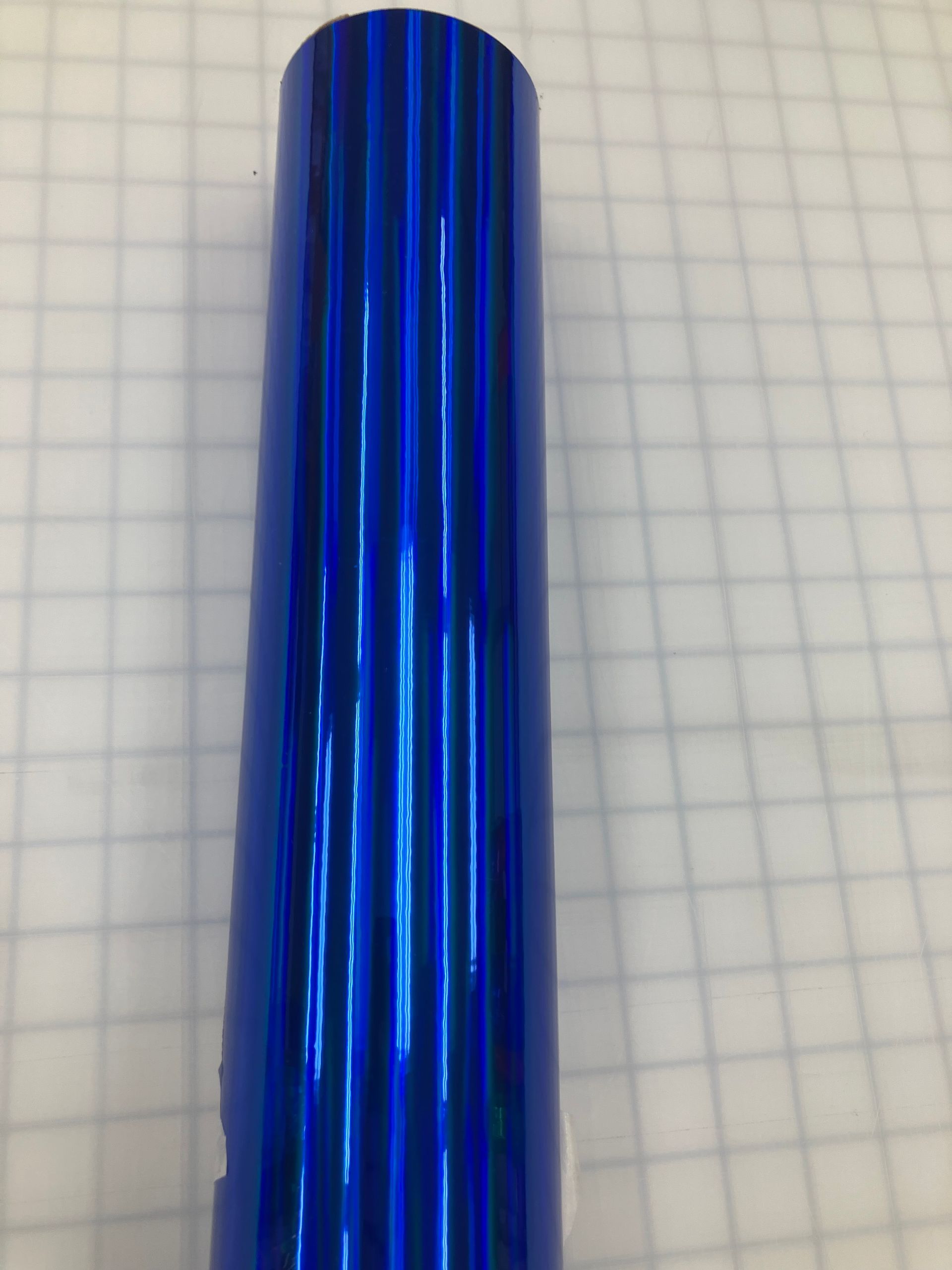 Blue ribbed cylindrical object on a light grid background