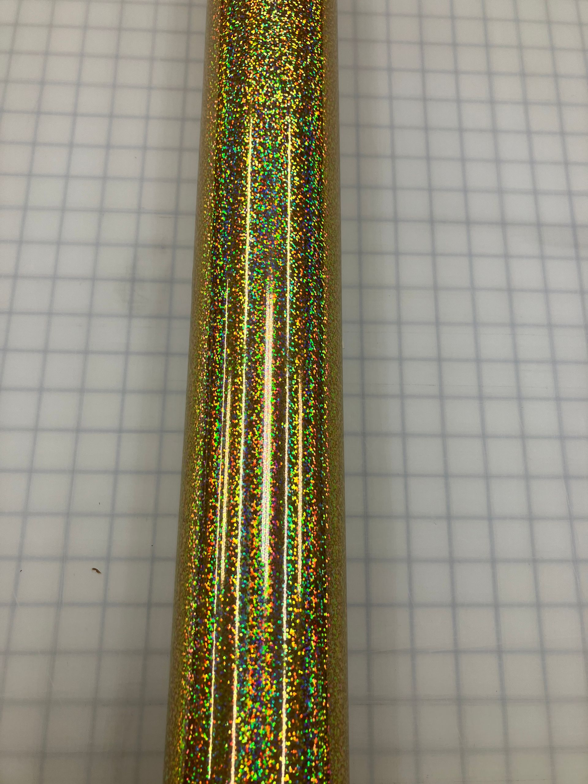 Gold and green glittery vertical ribbon on graph paper background