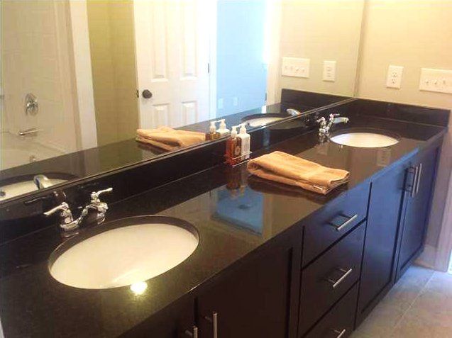 A bathroom with two sinks and a large mirror.