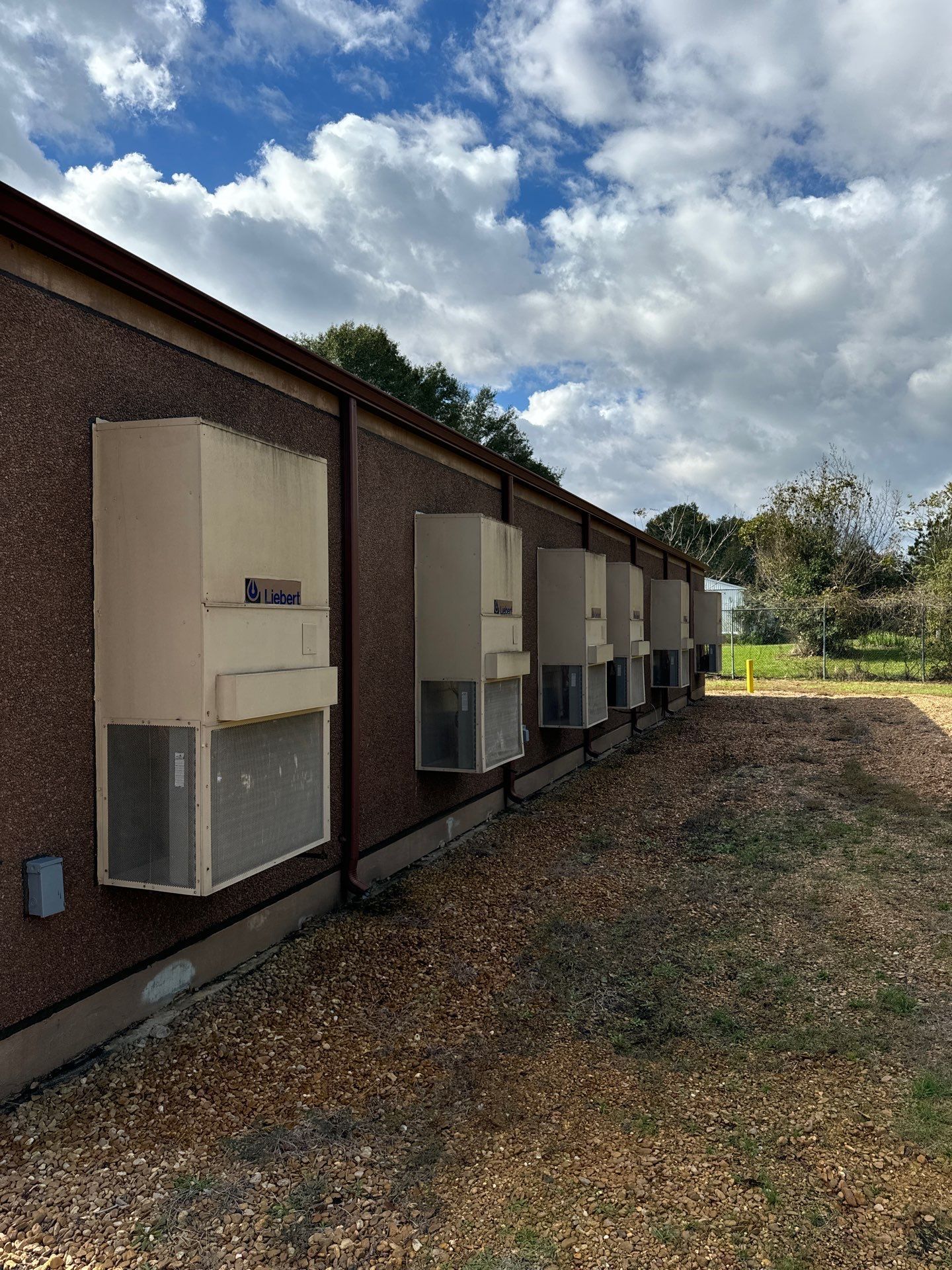A row of air conditioners on the side of a building.
