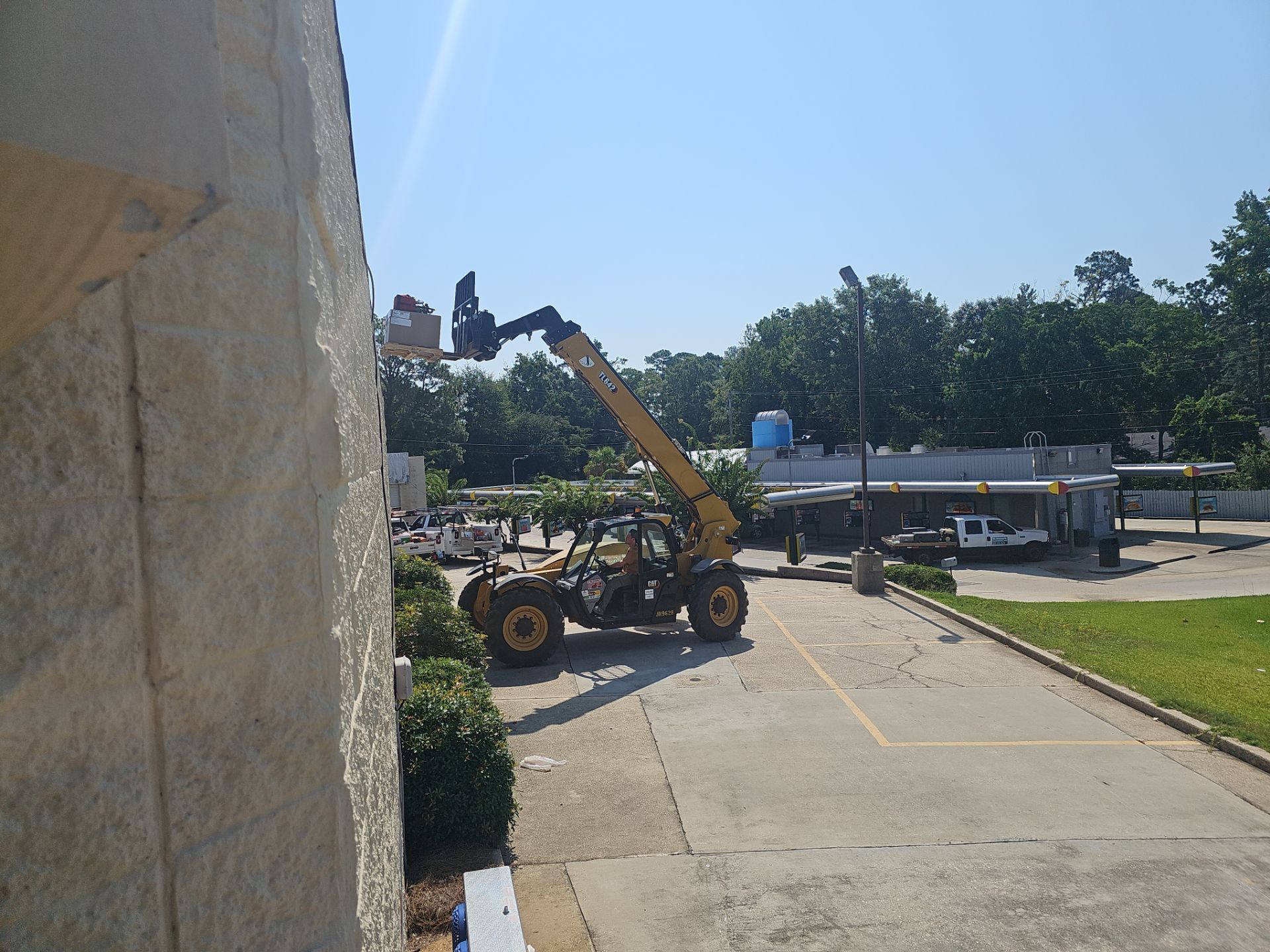 A yellow forklift is parked in front of a building