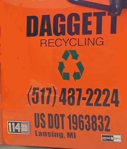 Orange Daggett Recycling truck door with logo, phone number, and Lansing, MI DOT markings