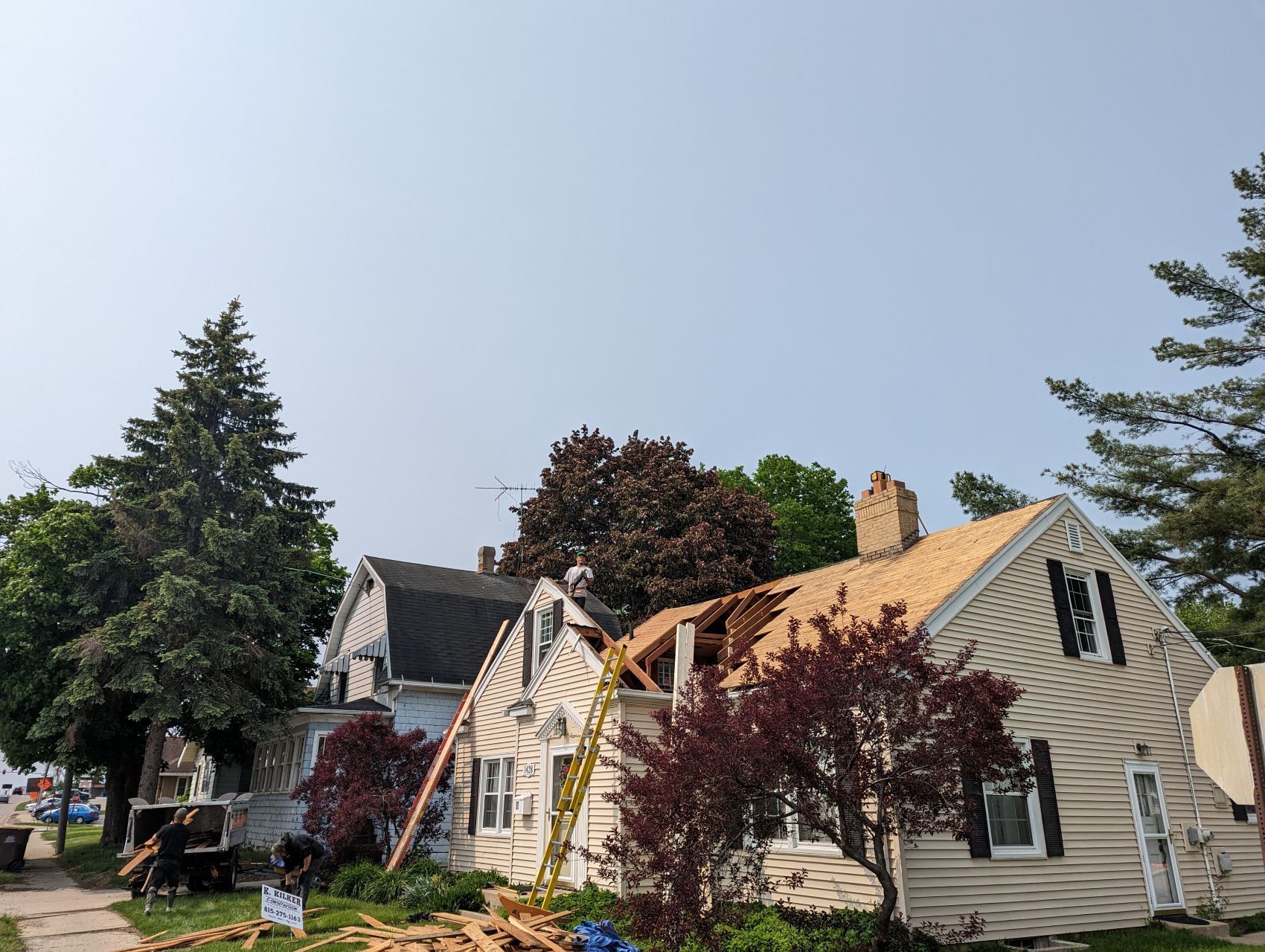 House under construction; roof being replaced; ladder leaning against side.