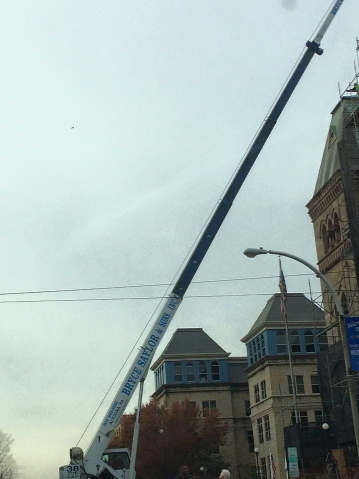 Tall crane beside historic buildings under an overcast sky