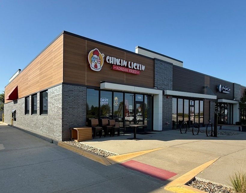 Chickin Lickin' restaurant exterior with brown, gray, and black facade; outdoor seating visible.
