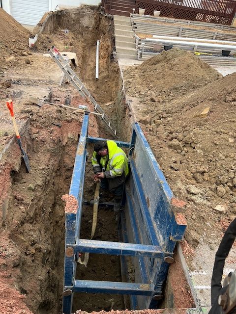 A man is digging a hole in the ground with a shovel.