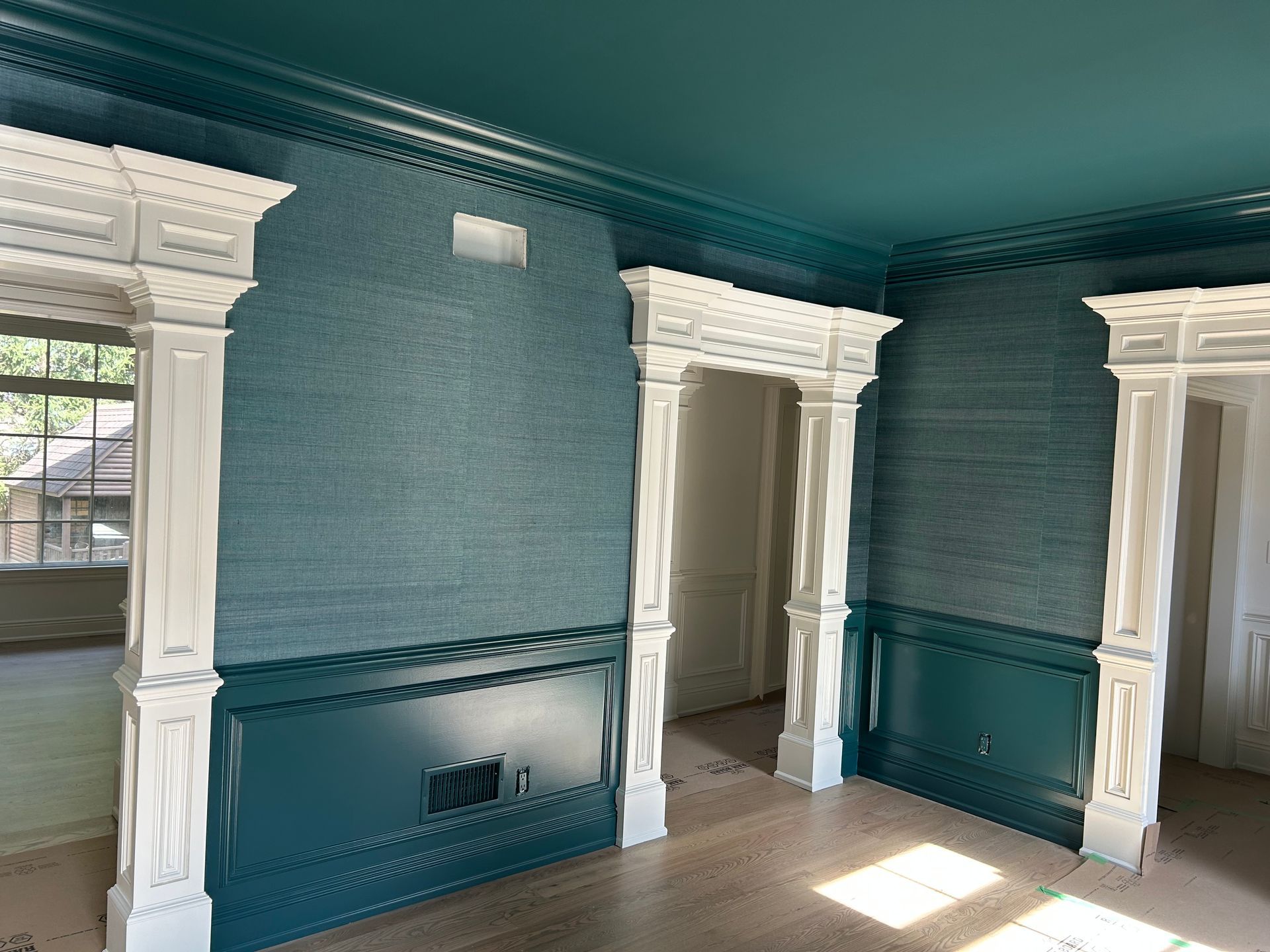 Room with teal walls, white trim, and architectural details.