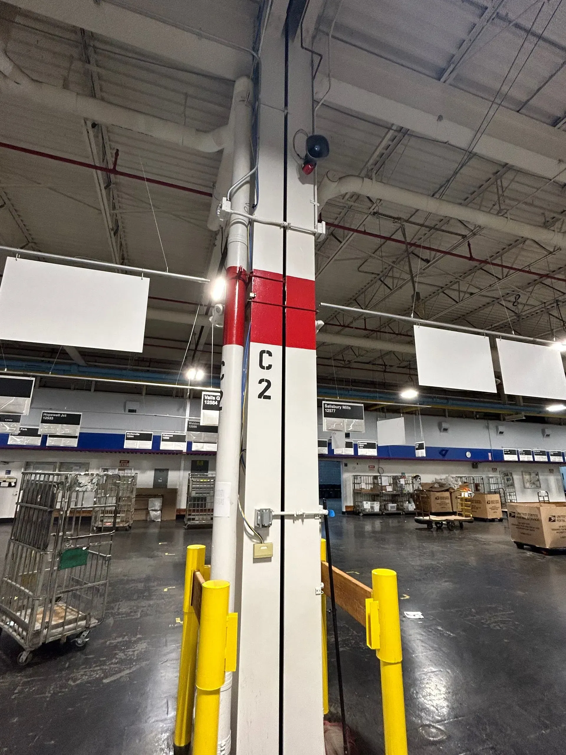 Tall white industrial column with red markings and 