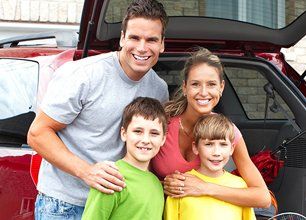 Family standing in front of a car