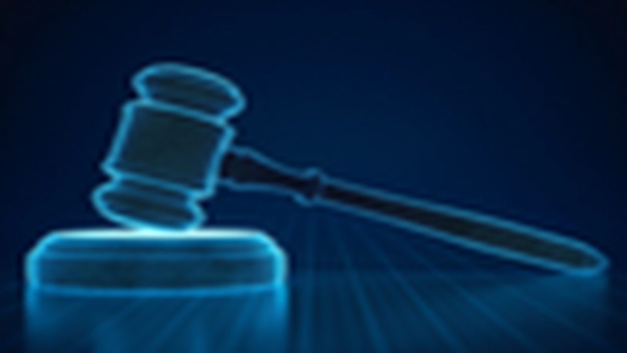 A digital image of a judge 's gavel on a blue background.