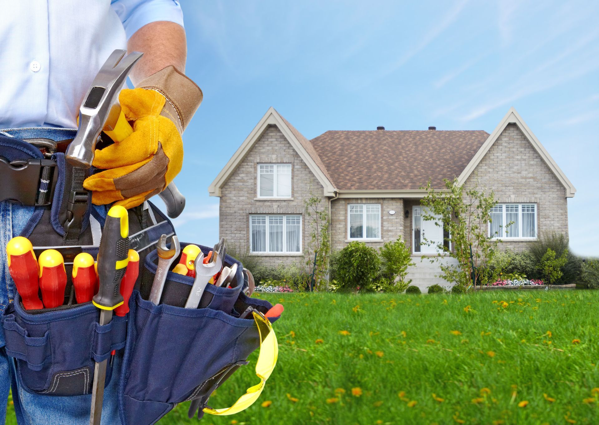 Handyman with tool belt in front of a house, holding a hammer, sunny day.