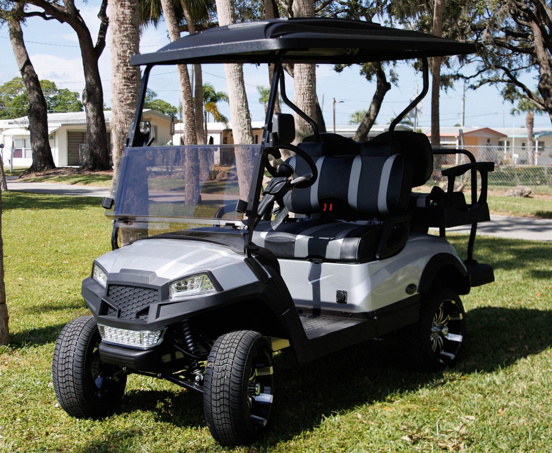 Silver golf cart with black accents, parked on grass.