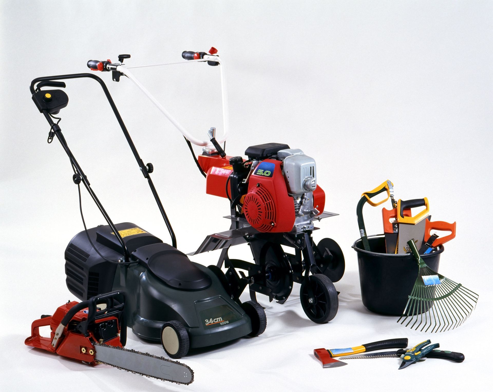 Assorted lawn and garden tools, including a push mower, trimmer, blower, and attachments on a white background