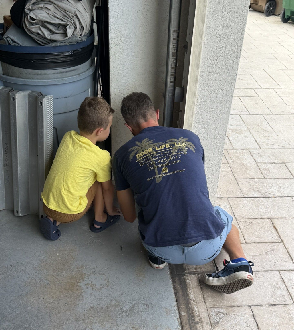 Person using a power drill to install garage door track hardware.
